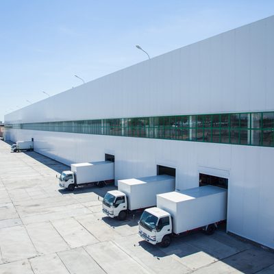 facade of an industrial building and warehouse with freight cars in length